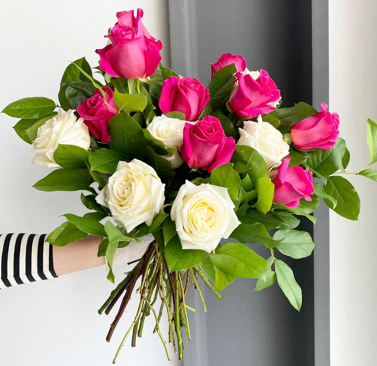 Florette BERLIN - A lovely bouquet with a mixture of white, dark pink roses, and lemon leaves. 