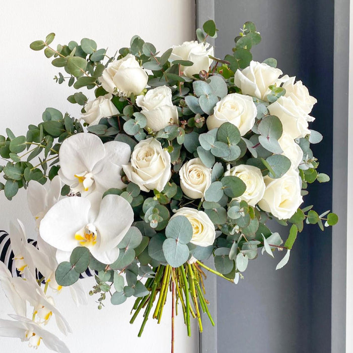Florette BROOKLYN - A lovely bouquet with eucalyptus, beautiful ruffly white roses and a white Phaleanopsis orchid.