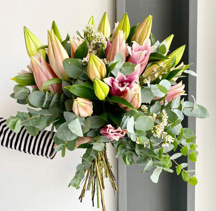 A lovely pink bouquet composed of oriental pink lilies, white wax flowers, and lots of eucalyptus cinerea.